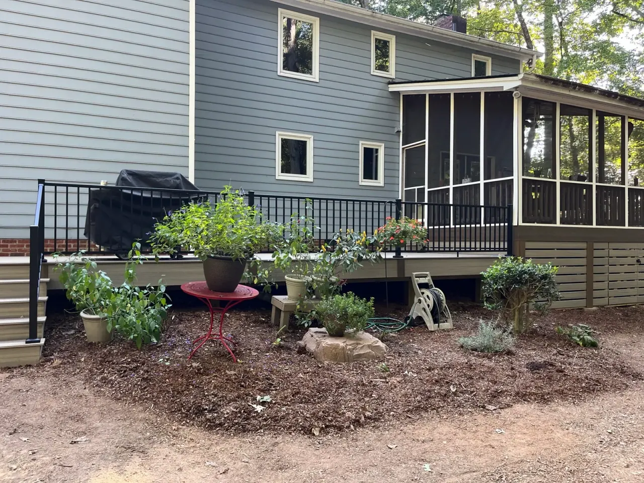 Deck and screened porch combination with black railing and horizontal skirting