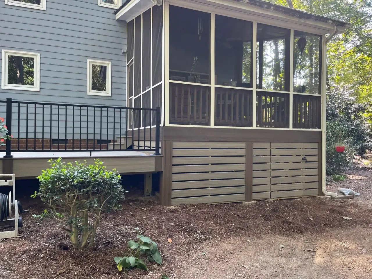 Screened porch with horizontal composite skirting and black aluminum railing