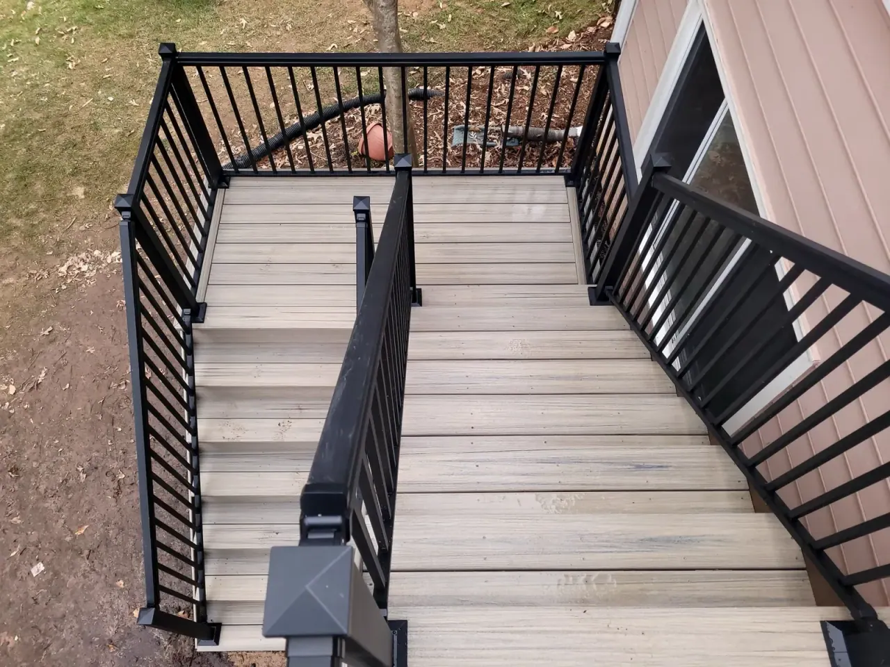 Overhead view of composite stair treads framed by black aluminum railing